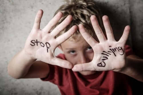 förhindra mobbning: pojke håller upp händerna som det står "stop bullying" på