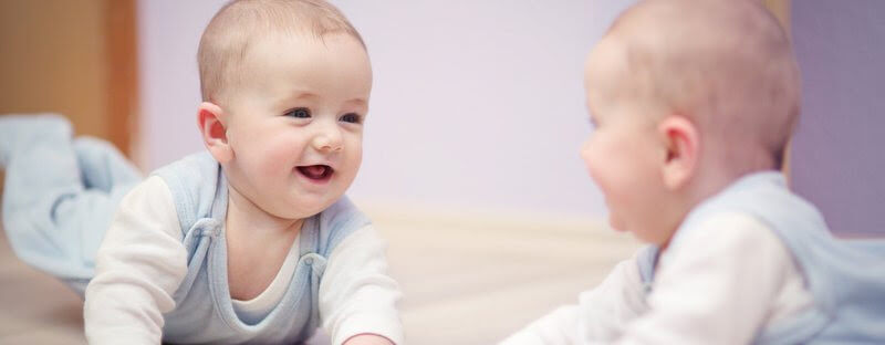 barns genetik: baby tittar i spegel