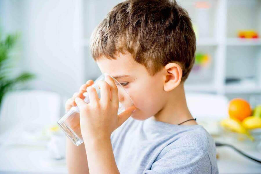 ketos hos barn: pojke dricker ett glas vatten