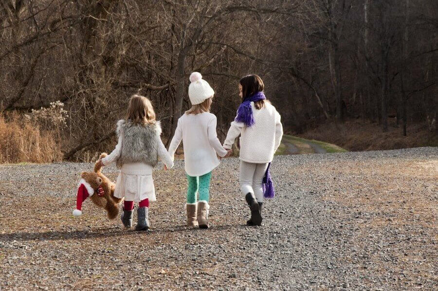 julplaner: tre vinterklädda barn ute