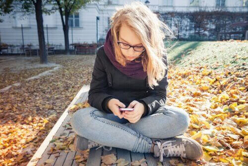 tonåring kollar Sociala medier på sin mobil