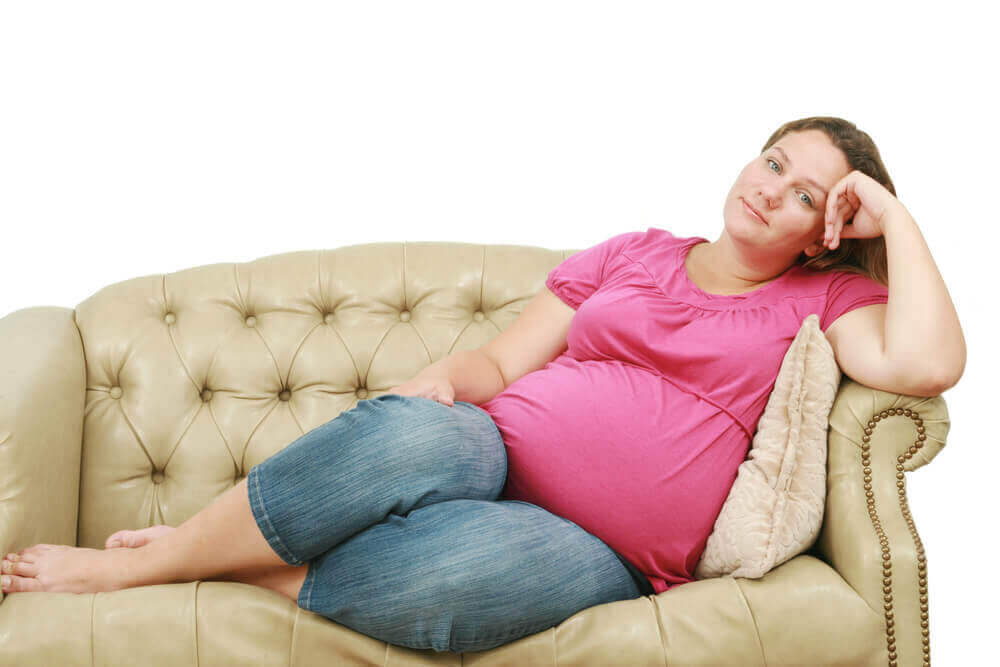 trauma och graviditet: trött gravid kvinna på soffa
