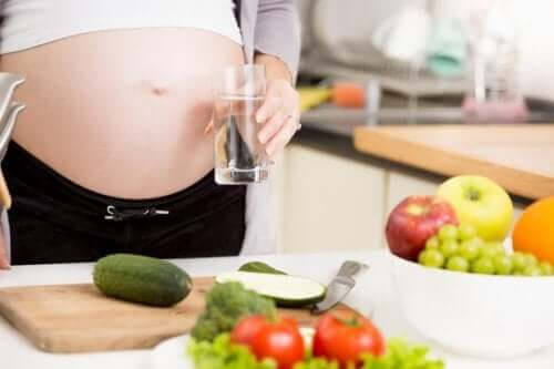 kosttillskott för gravida: gravid kvinna framför grönsaker