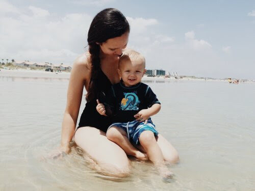 skydda barn mot solen: baby på stranden med mamma