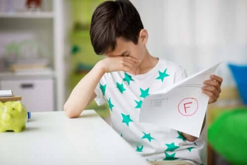 misslyckas i skolan: ledsen pojke med underkänt prov