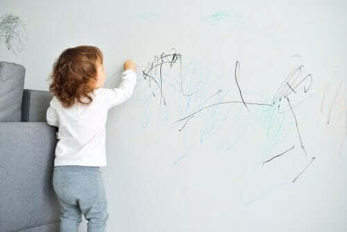 litet barn ritar på väggen