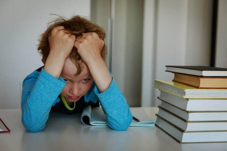 dynamiskt tänkande: frustrerad pojke vid hög med böcker