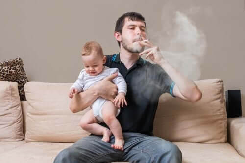 effekterna av tobak på barn: pappa som röker håller baby