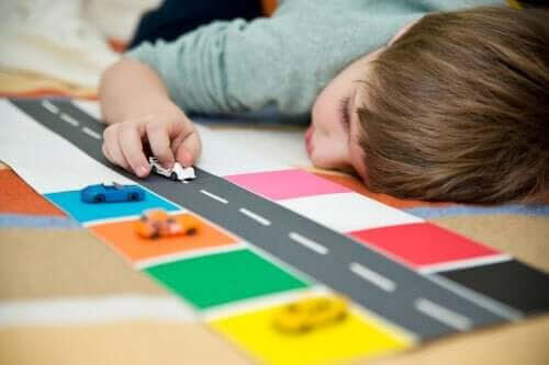 skolgång för barn med autism: pojke leker med bilar