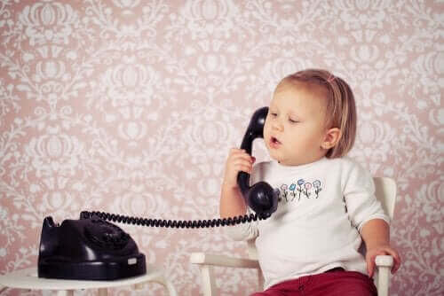 utvecklingen av språk: småbarn leker med telefon