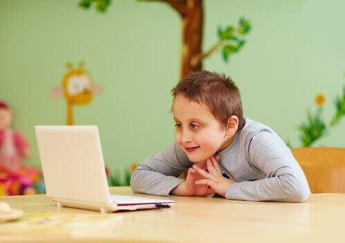 Barn med särskilda behov: pojke tittar på laptop
