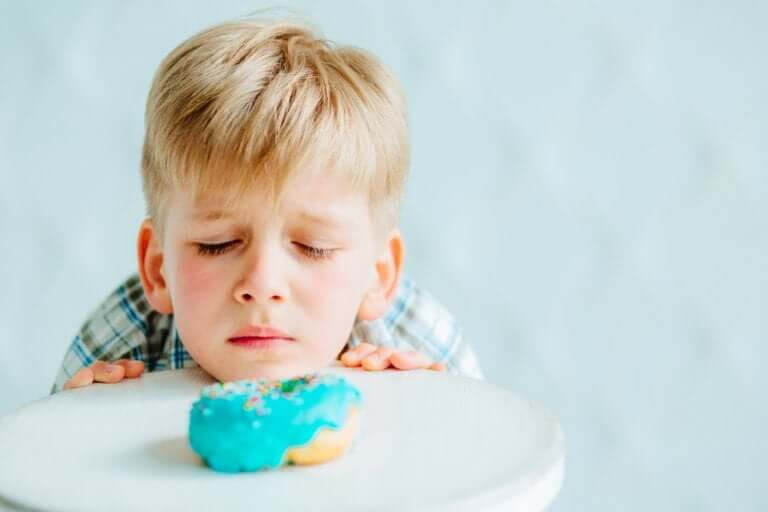glutenintolerans hos barn: pojke tittar sorgset på bakverk