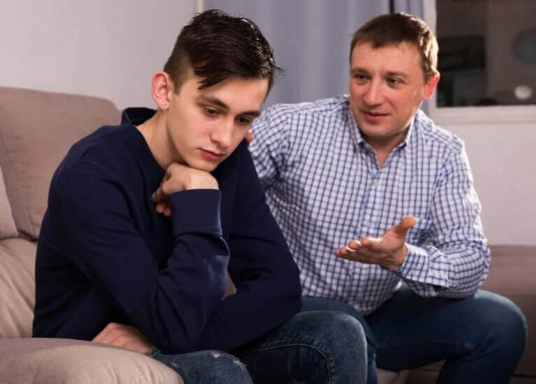 Kommunicera med tonåringar: pappa och tonårsson på soffa