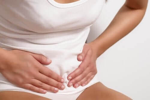 premenstruellt syndrom: kvinna håller sig för magen