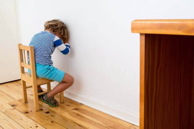 positiva och negativa straff: pojke sitter vänd mot vägg