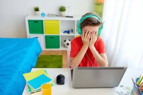 nätmobbning: pojke ser förtvivlad ut framför dator