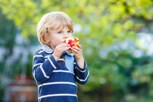 Ett barn som äter ett äpple.