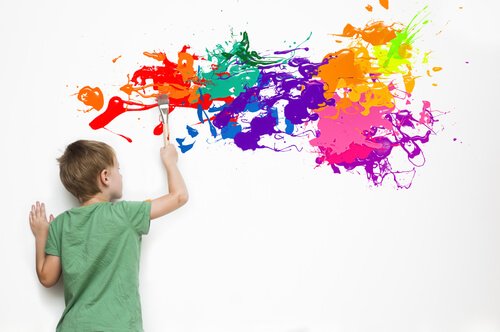 Ett särbegåvat barn målar på väggen.