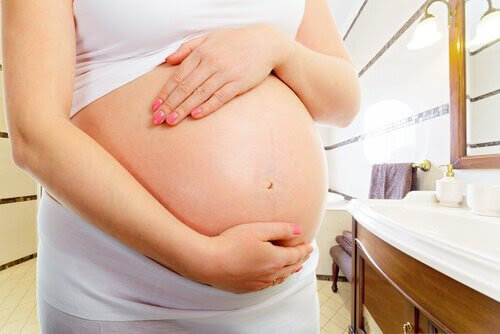 slempropp: kvinna håller om sin gravida mage