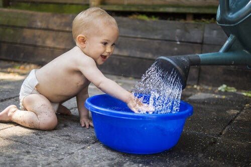 barn i 11:e månaden leker med vatten