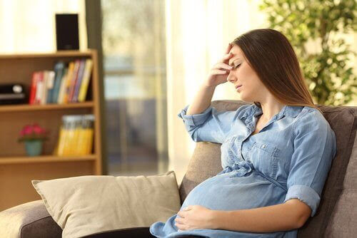 gravid kvinna oroar sig i soffa