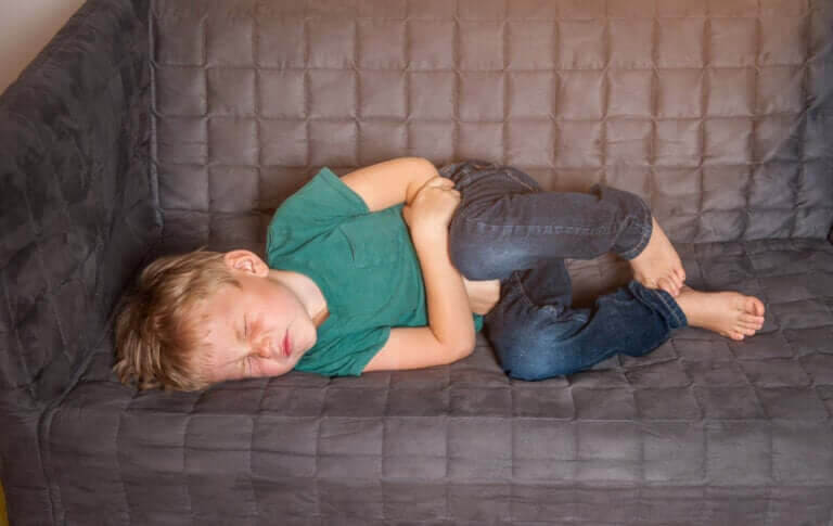 Stolpiller: barn med magvärk ligger på soffa