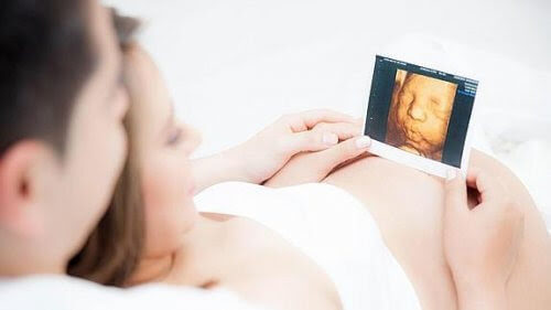 gravid kvinna och man tittar på ultraljudsbild