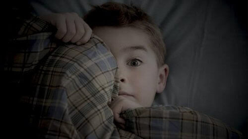 rädda för att vara ensamma: rädd pojke i säng
