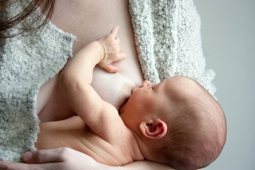 Ammande bebis dricker råmjölk