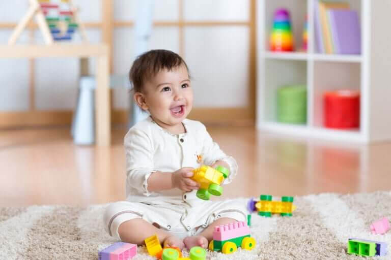 barns motoriska färdigheter: baby leker med leksaker