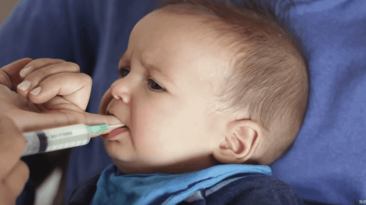 Tuttförvirring: baby suger på finger med matningsslang