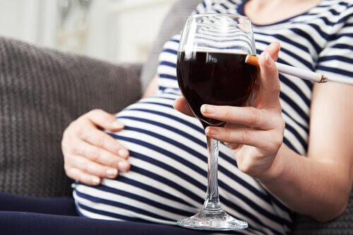 fetalt alkoholsyndrom: gravid kvinna med vinglas och cigarett