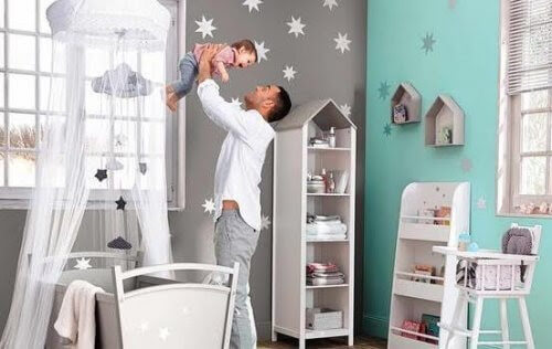 din babys rum: pappa håller upp baby