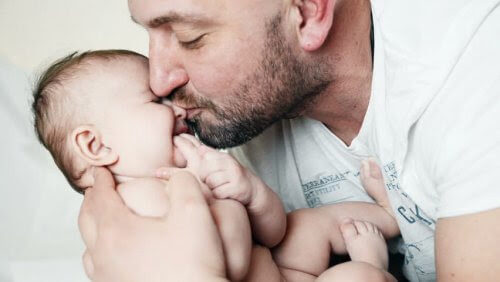 fäder känner sig isolerade: pappa pussar baby