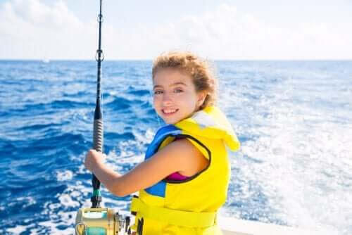 seglar med barn: flicka med fiskespö på båt