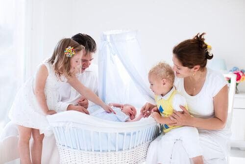 din babys första säng: familj runt baby i vagga