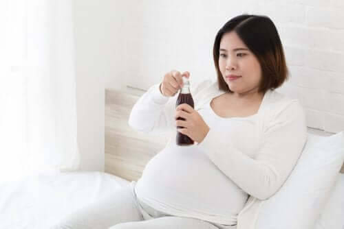 koffein under graviditeten: gravid kvinna med läsk