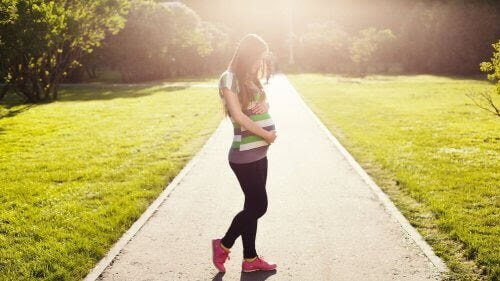 löpning och graviditet: gravid kvinna i träningskläder
