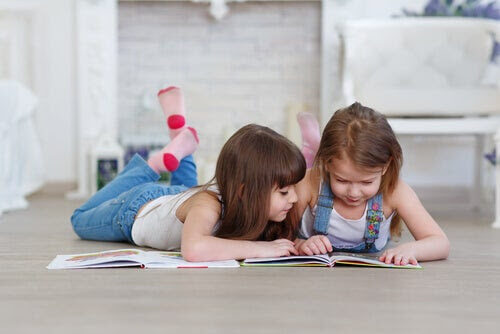 lära barn att hata att läsa: två barn ligger på golvet och tittar i bok