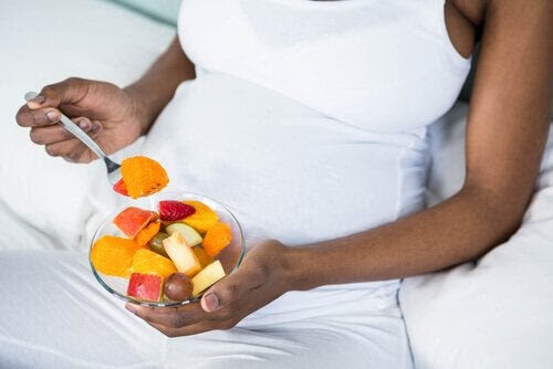 mellanmål för tredje trimestern: gravid kvinna med fruktskål