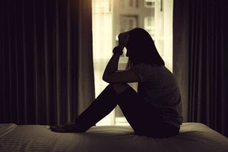 depression påverkar förhållandet: kvinna sitter på golvet i mörkt rum