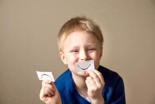 socio-emotionella förmågor: pojke med lappar med glad och ledsen mun