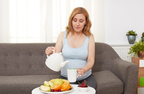 Halsbränna och matsmältningsbesvär under graviditeten: gravid kvinna häller upp te