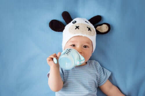 besök med din bebis: baby i söt mössa och med nappflaska