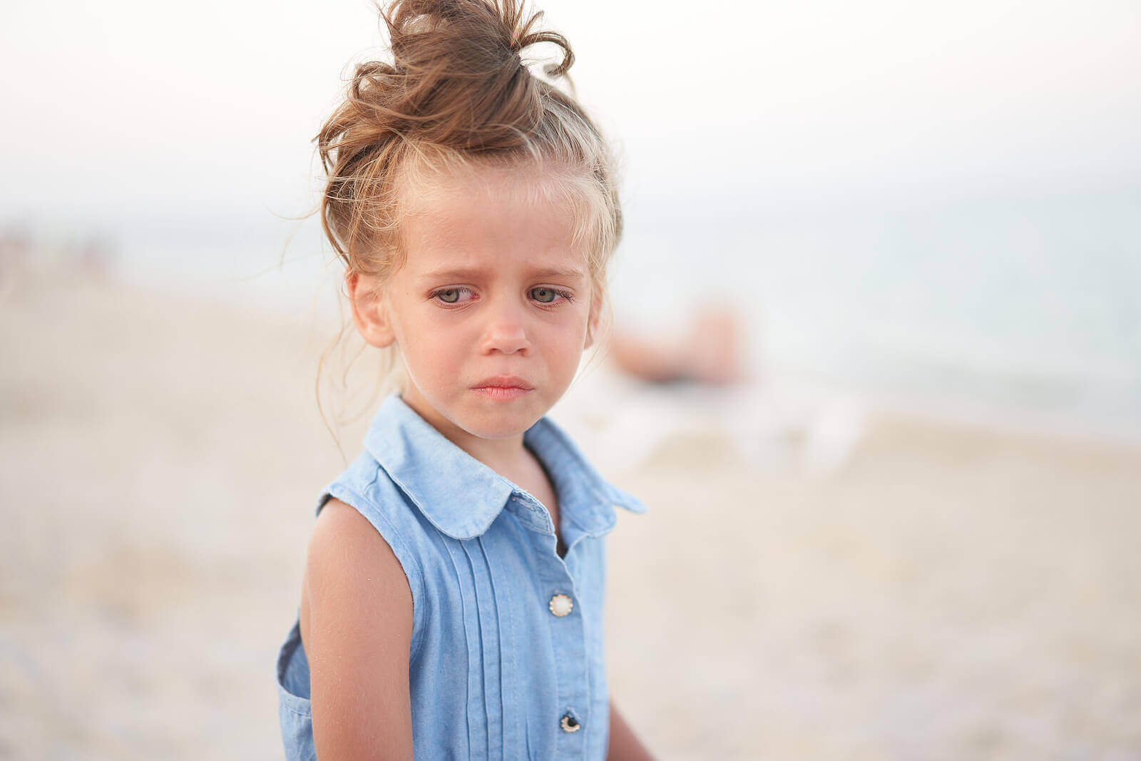 ett barn är ledset på strand