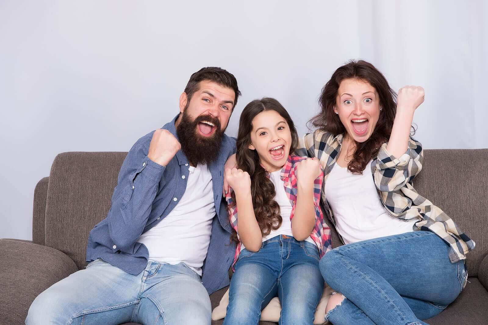språklig kompetens hemma: glad familj i soffa