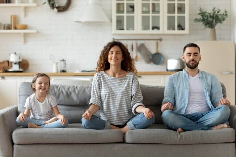 Mindfulness och meditation: familj mediterar i soffa