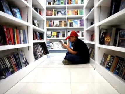 Ett barn som läser serier i en butik. 
