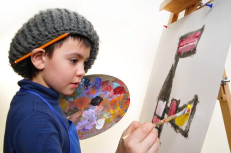 Hobbys för barn: En pojke som målar en tavla. 