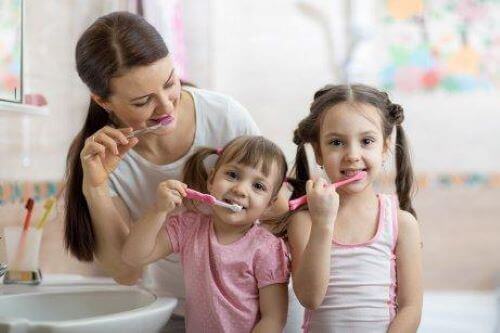 Familj borstar tänder tillsammans.
